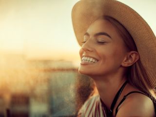 A Woman Smiling With A Hat